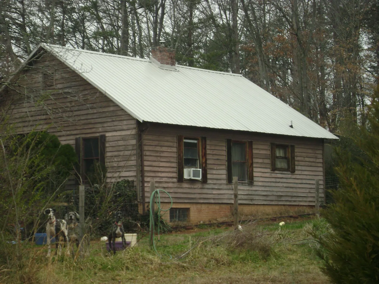 White metal roof on an old wood sided farmhouse, from a Asphalt Shingle Roof Repair job in Mc Henry